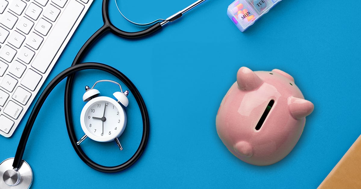 A stethoscope on a solid blue background with a computer keyboard, alarm clock, and piggy bank.